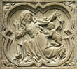 Panel 08:04 - Kneeling woman raising her cloak to reveal an infant boy
